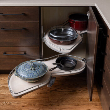 Corner base cabinet swing out shelves from Dura Supreme Cabinetry. These uniquely-shaped shelves pivot and glide out of the cabinet for complete access to items stored in the farthest corners.