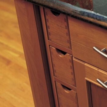 Vertical apothecary drawers in a cherry wood kitchen island with a rich-warm stain color. Kitchen island cabinets and storage from Dura Supreme.