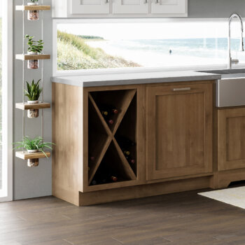 A large X patterned wine rack shelf in a base cabinet with light stained wooden kitchen cabinets.