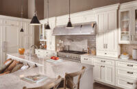 A beautiful L-shaped kitchen with an L-shaped kitchen island with a built-in breakfast nook integrated into the island.