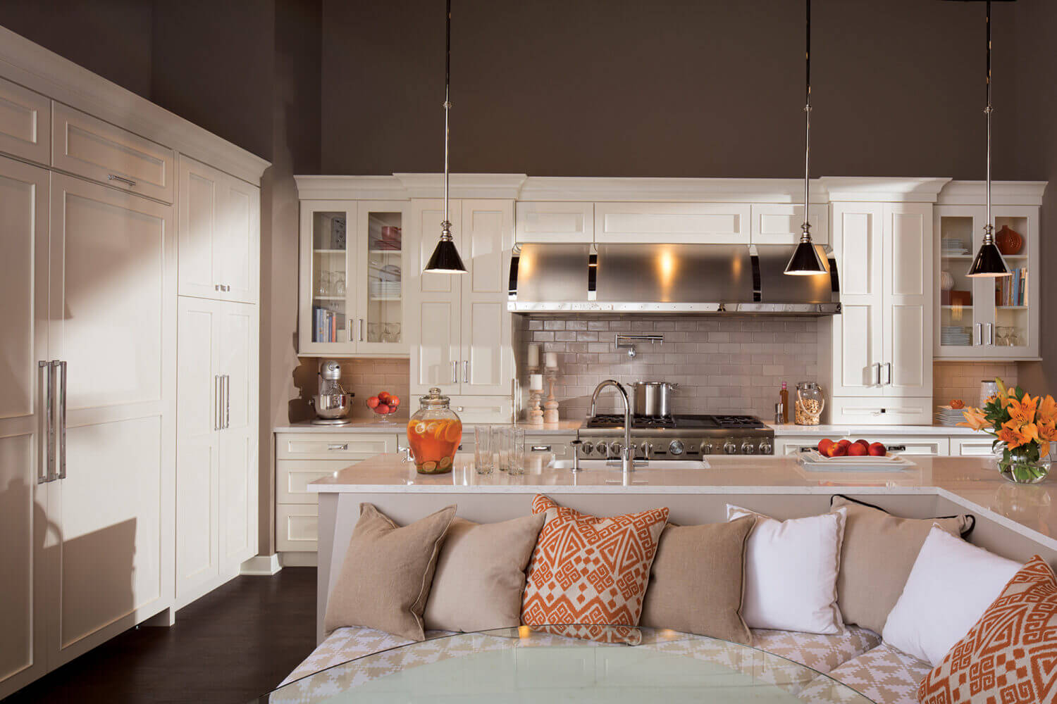 A white transitional kitchen with a sleek flat panel door style. The back of the kitchen island transforms into a breakfast nook with comfortable dining room seating for the whole family.