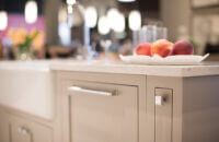 A beige kitchen island with shaker styled inset cabinets from Dura Supreme.