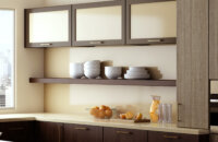 This luxurious, lofty kitchen features glimmery hints of brushed brass with horizontal wall cabinet doors with satin glass doors. A long floating shelf below the line of wall cabinets creates a beautiful and accessible place for every day dishware.