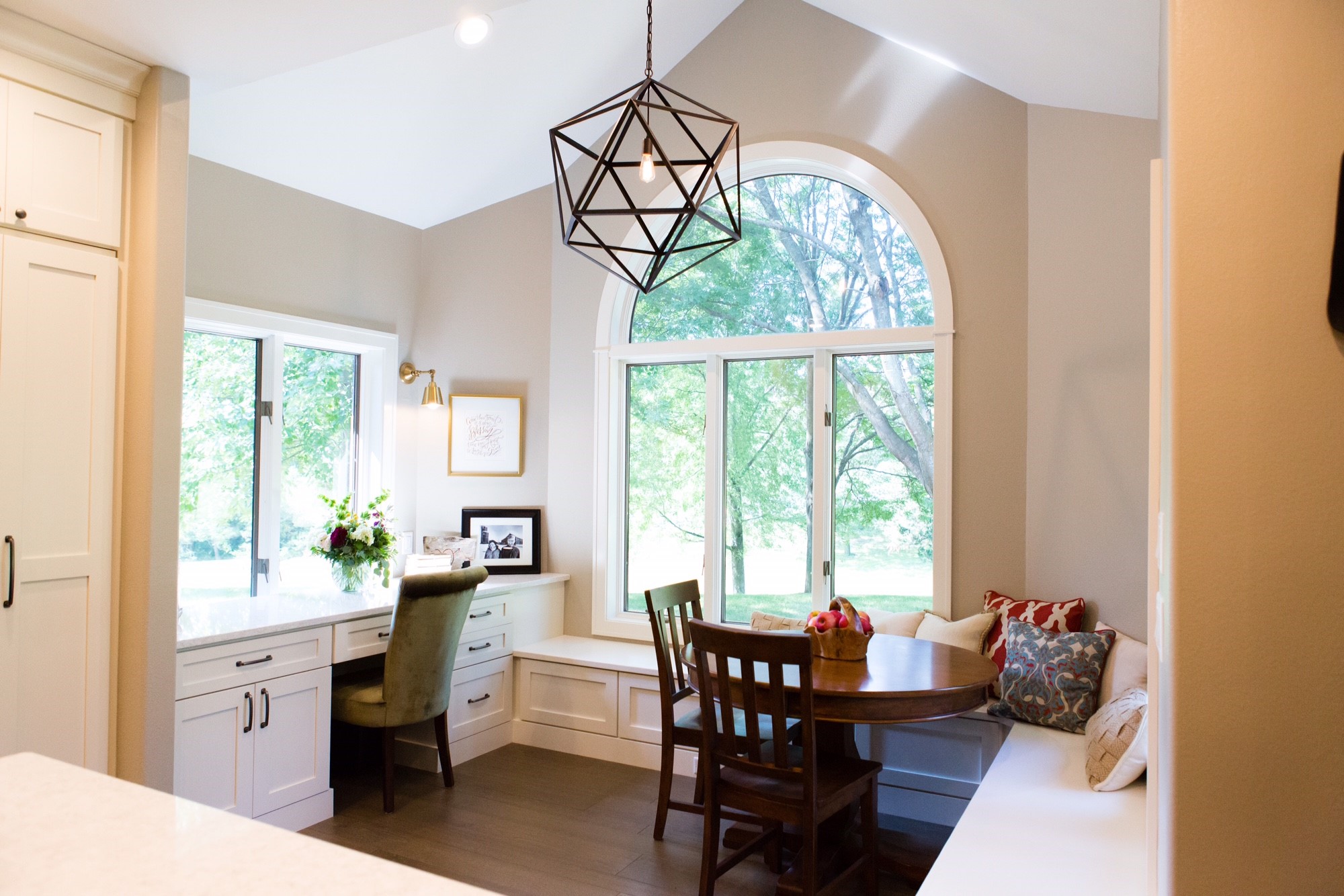 A dining room design with a built-in home office desk and breakfast nook.