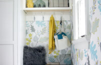 A small entryway storage cabinet with a boot bench with two small drawers and a tall cabinet for hanging coat storage.