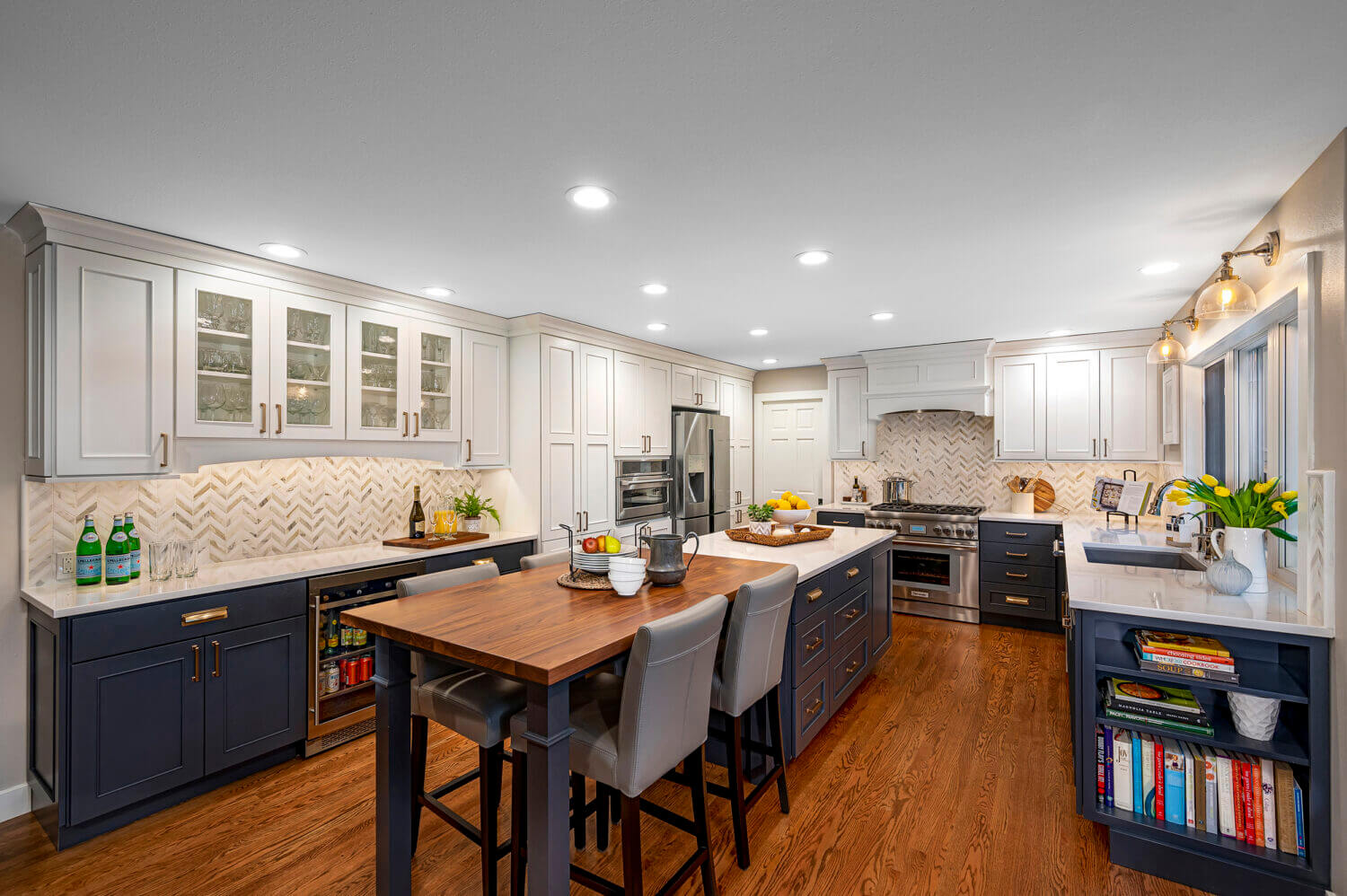 A long kitchen island that is half a workspace with cabinet storage and half casual dining room seating.