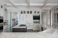 A glamorous all white kitchen design with white painted and gray stained cabinets.