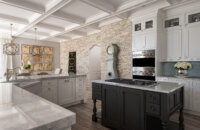 A luxurious kitchen with a black furniture styled kitchen island an L-shaped kitchen island and white painted cabinetry.