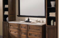 A masculine bathroom vanity with furniture-like details and two free standing linen cabinets.