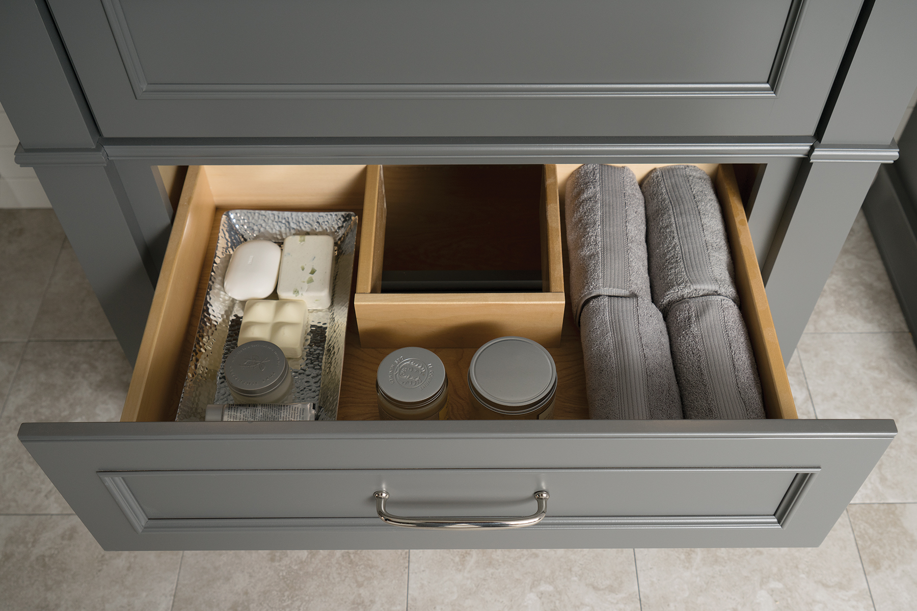 A Plumbing Drawer in a vanity cabinet. The drawer shape wraps around the plumbing fixtures under the sink.
