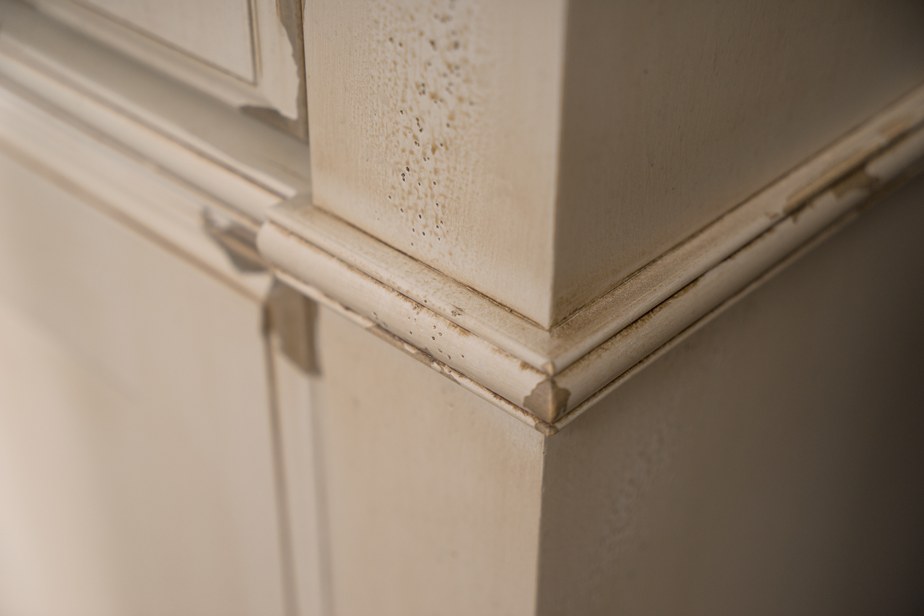 A close up of the molding details on the corner of a furniture styled vanity.