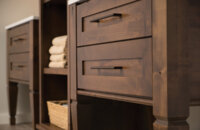 A 3-piece-set of bathroom furniture with two vanities and a free-standing linen cabinet.