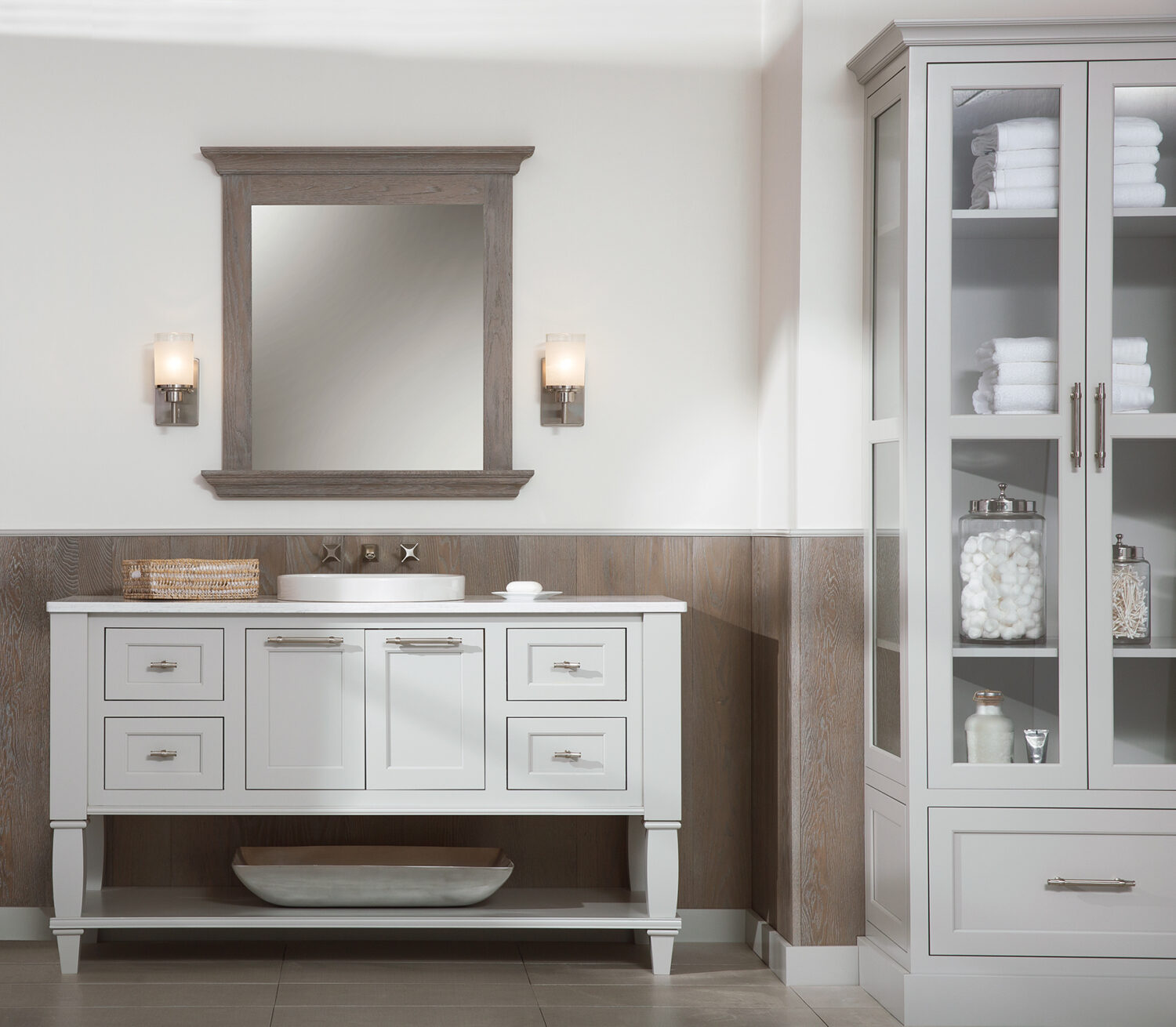 A coastal style master bathroom with a freestanding furniture style vanity that was customized to fit the homeowner's style preferences. The cool gray finish looks crisp and fresh against the weathered wood wall panels and vanity mirror.