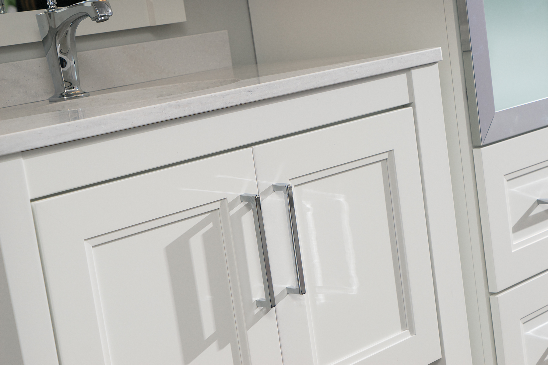 A close up angled shot of white painted bathroom cabinets.