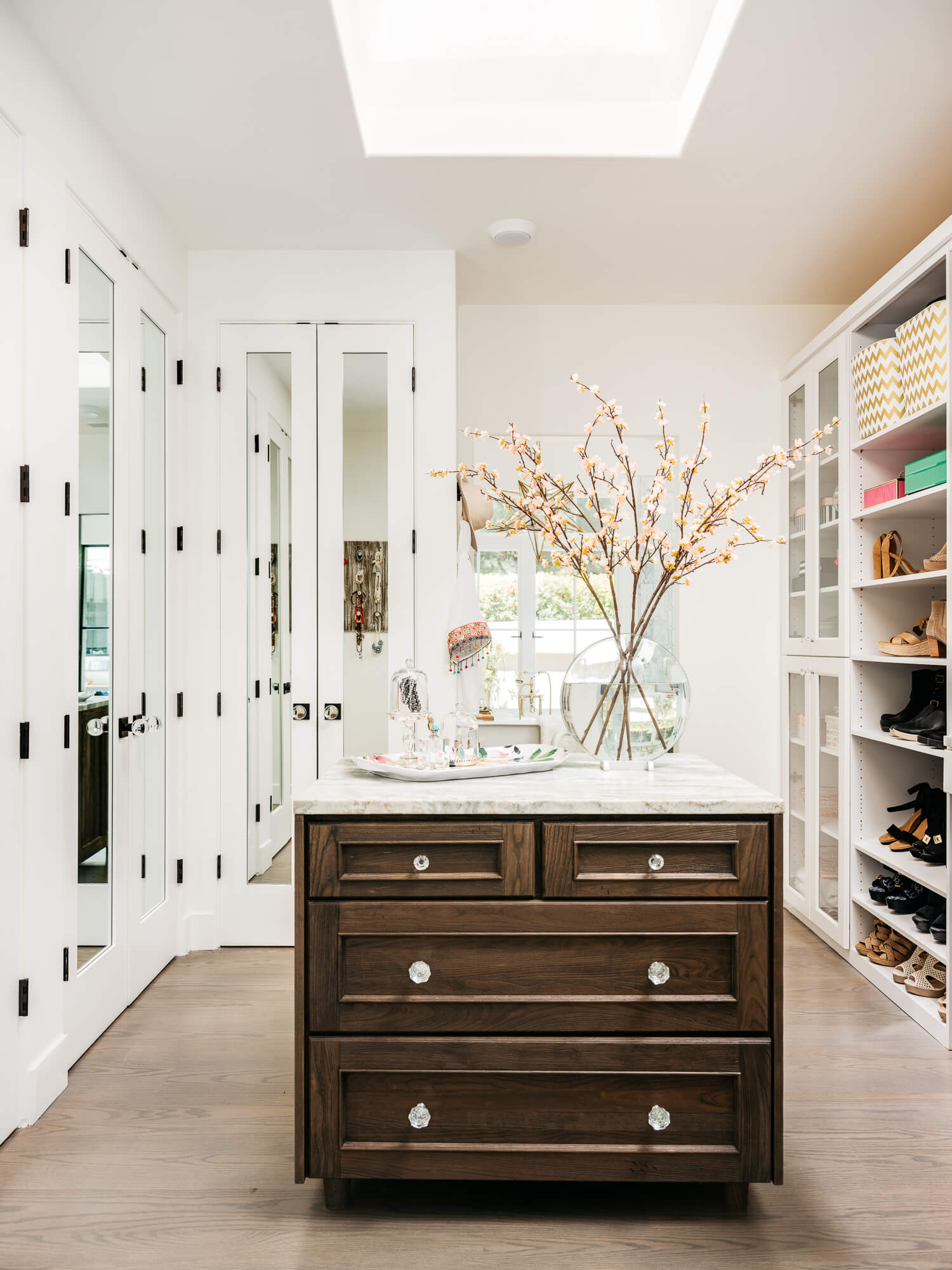 A fabulous walk-in closet with a master bedroom closet island for clothing storage and a work surface for preparing outfits and folding clothes to put away.