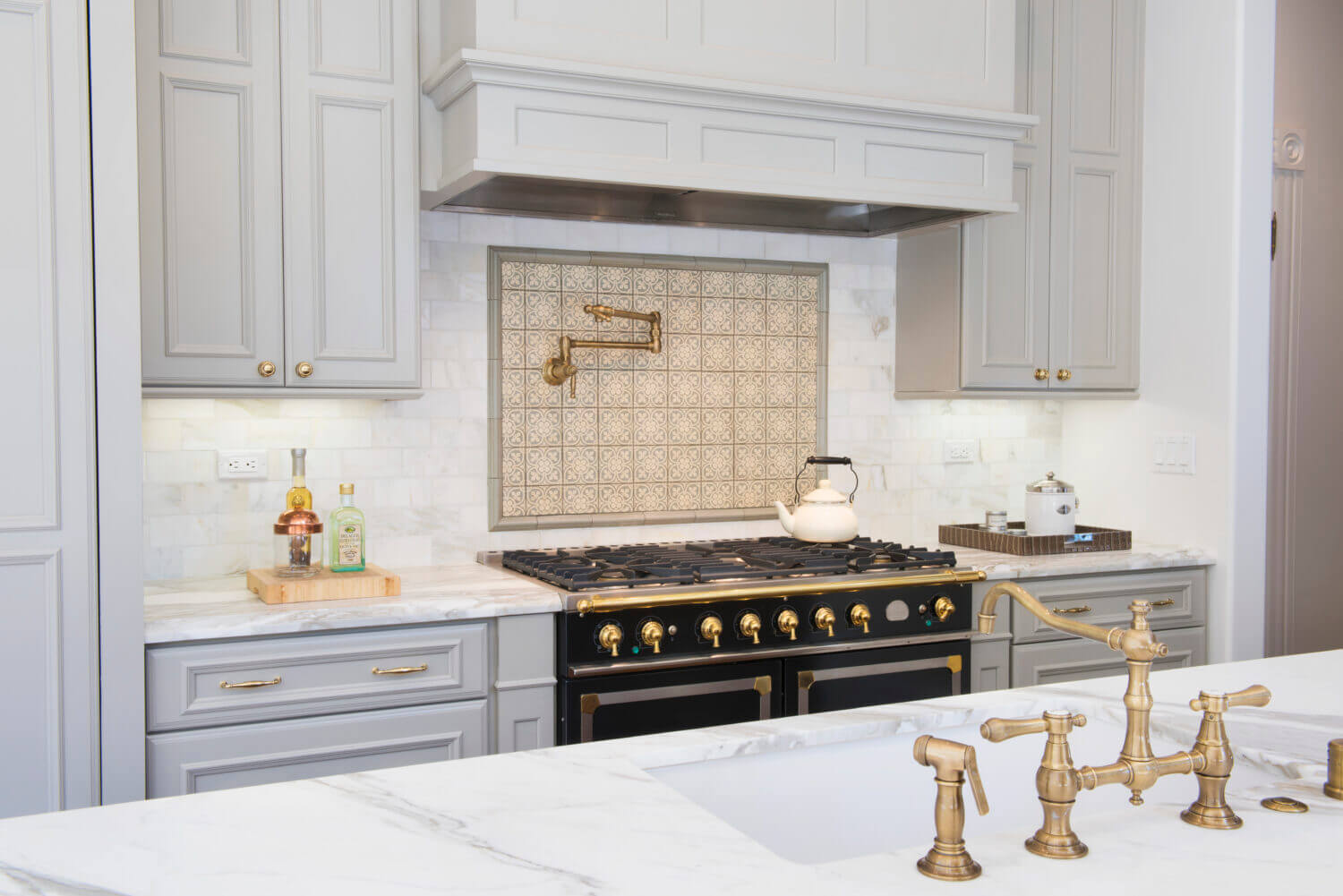 This elegant Dura Supreme kitchen adorned with brassy gold accents was designed by Joyce Van Den Dungen Bille of Gilmans Kitchens and Baths, California.
