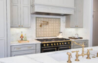 This elegant Dura Supreme kitchen adorned with brassy gold accents was designed by Joyce Van Den Dungen Bille of Gilmans Kitchens and Baths, California.