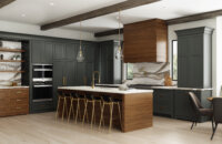 Dark gray-green and rich stained wood kitchen with modern farmhouse style, shiplap wood hood, shiplap kitchen island end cap, and brassy hardware and fixtures. Features floor-to-ceiling dark gray painted cabinets.