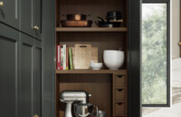 A baking center larder cabinet from Dura Supreme Cabinetry. A countertop standing larder cabinet provides an orderly place to house appliances, like a large mixer. Thoughtfully planned shelves and cubbies provide dedicated space for an assortment of baking gadgets, pantry goods, and measuring cups, keeping them easy to find and at your fingertips. When you’re done, simply wash up and close the cabinet and your kitchen is clean and clutter-free! Specialized internal features include an optional Flat Roll-Out Shelf and Pocket Doors.