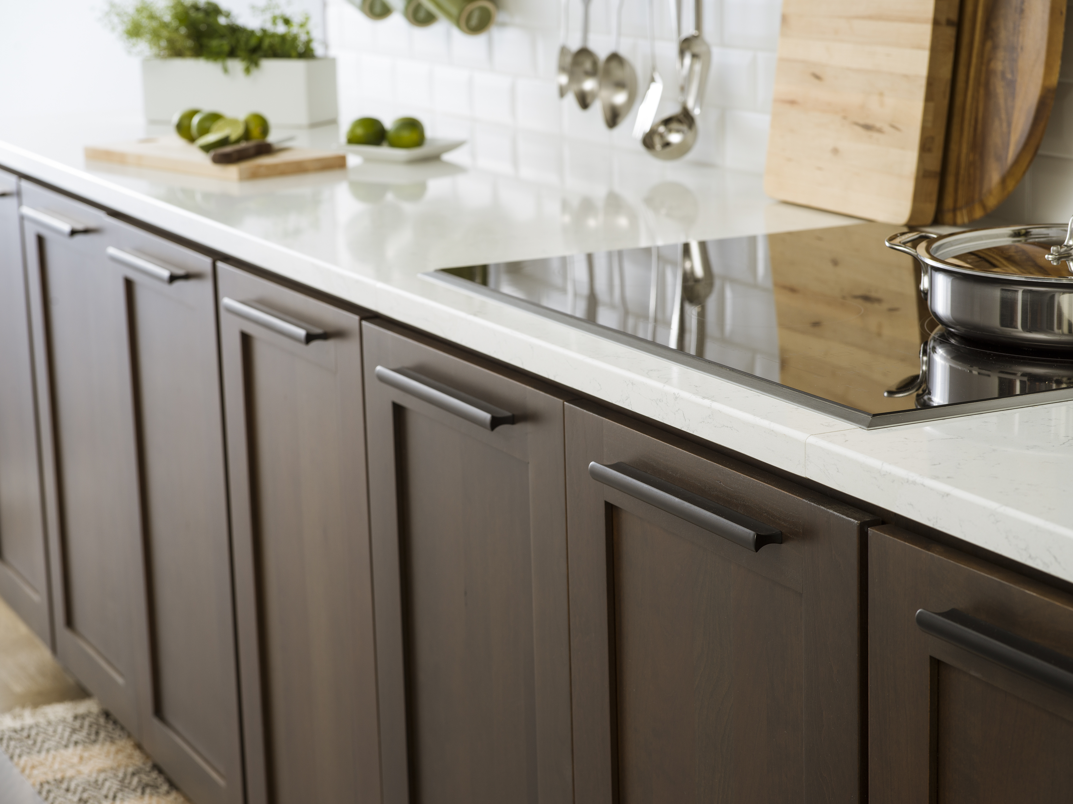 Cherry kitchen cabinets with a dark brown stain color with bright white countertops in a modern industrial style kitchen remodel.