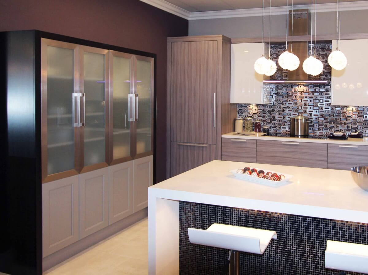 A contemporary kitchen design with multiple cabinet colors and materials.