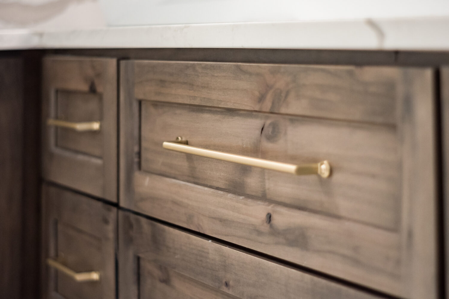 A close up of knotty alder cabinets with a brown gray stain color.