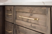 A close up of knotty alder cabinets with a brown gray stain color.