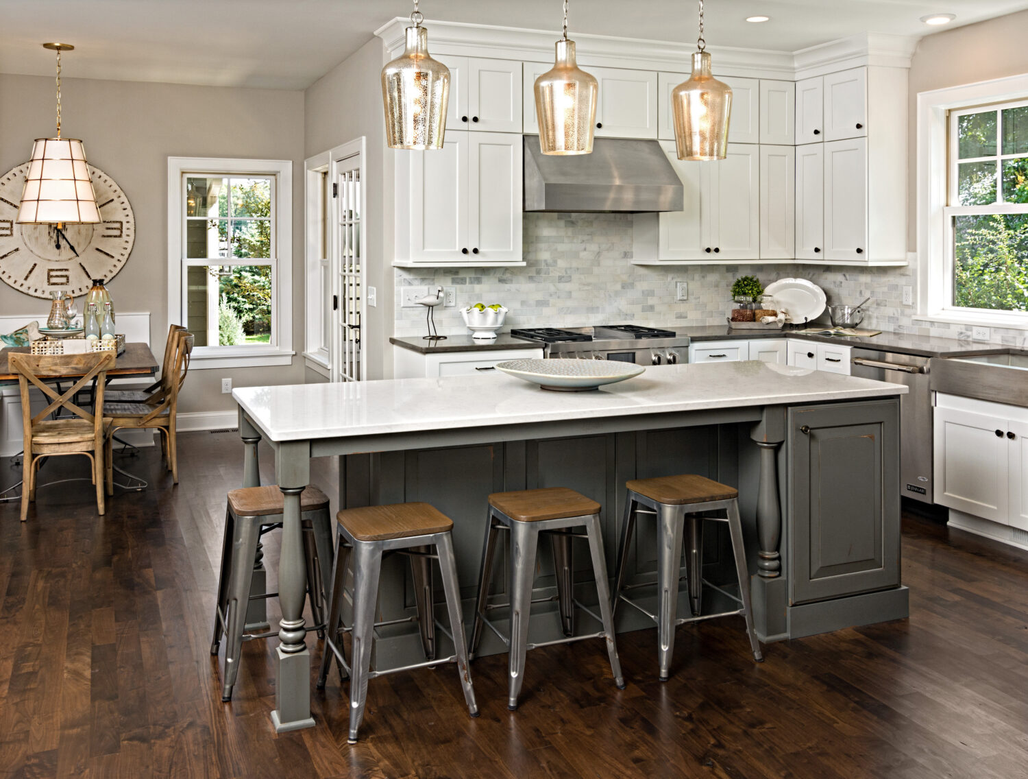 This transitional style kitchen was remodeled with white and rustic gray painted cabinets. The kitchen island features a distressed painted finish in a dark gray paint color with ornate turned posts.