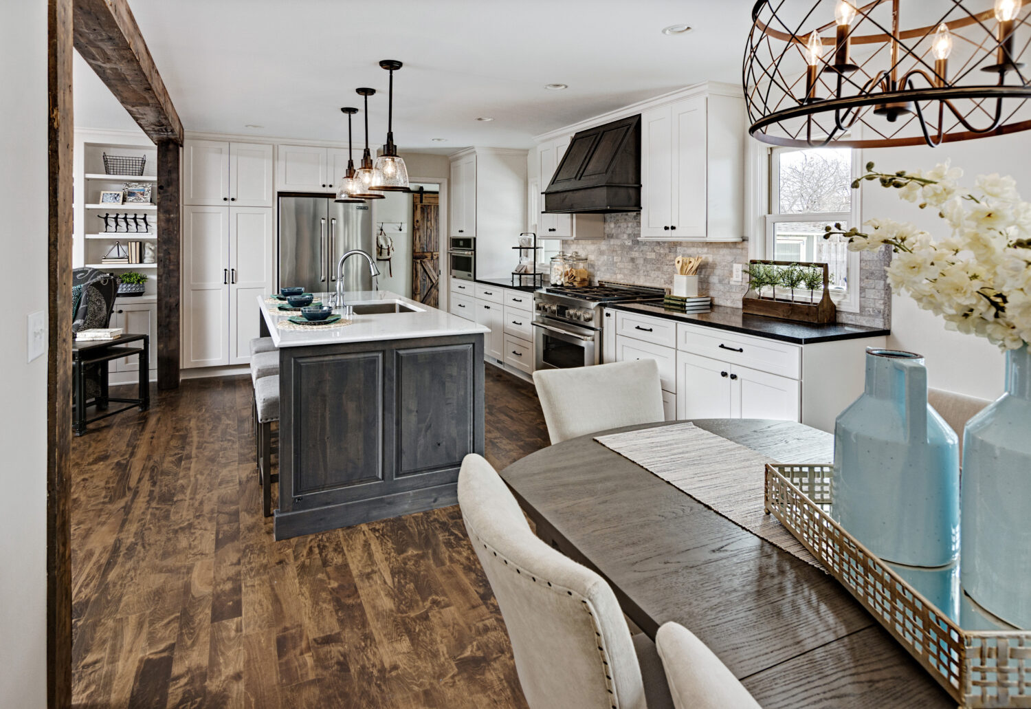 A view from the dining room into the kitchen with white and gray stained cabinets.