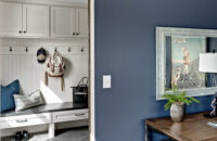 A view into the mudroom entry from the home office with a boot bench and locker cabinets with hooks.