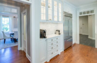 A white painted kitchen design with classic mullion glass doors.