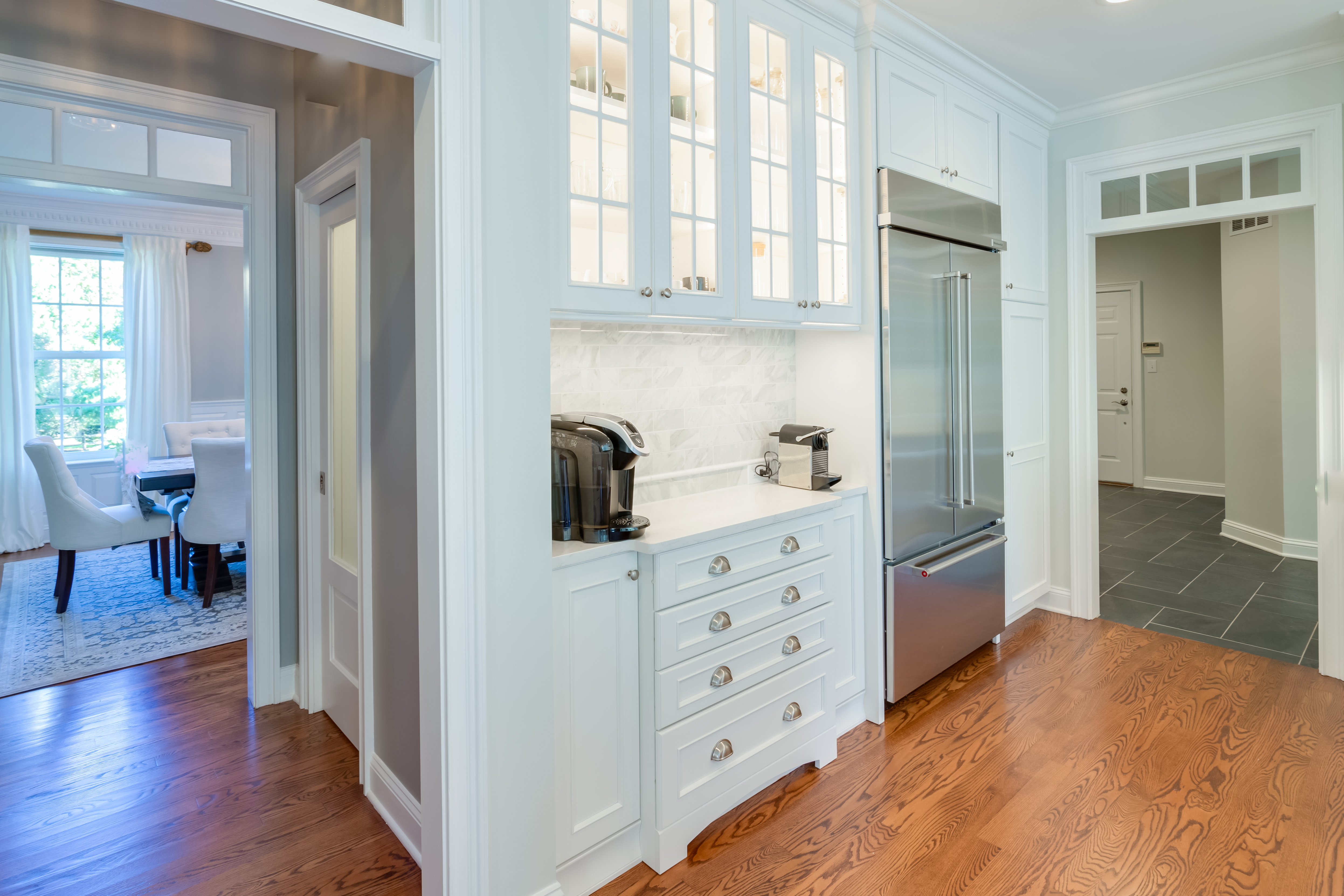 A white painted kitchen design with classic mullion glass doors.