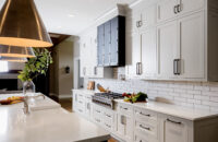 An elegant modern farmhouse kitchen design with sleek framed kitchen cabinets with inset cabinet door construction. The kitchen cabinetry is shown in an off-white painted finish with a classic shaker inset door style.