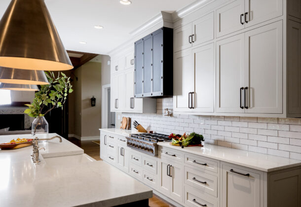 An elegant modern farmhouse kitchen design with sleek framed kitchen cabinets with inset cabinet door construction. The kitchen cabinetry is shown in an off-white painted finish with a classic shaker inset door style.