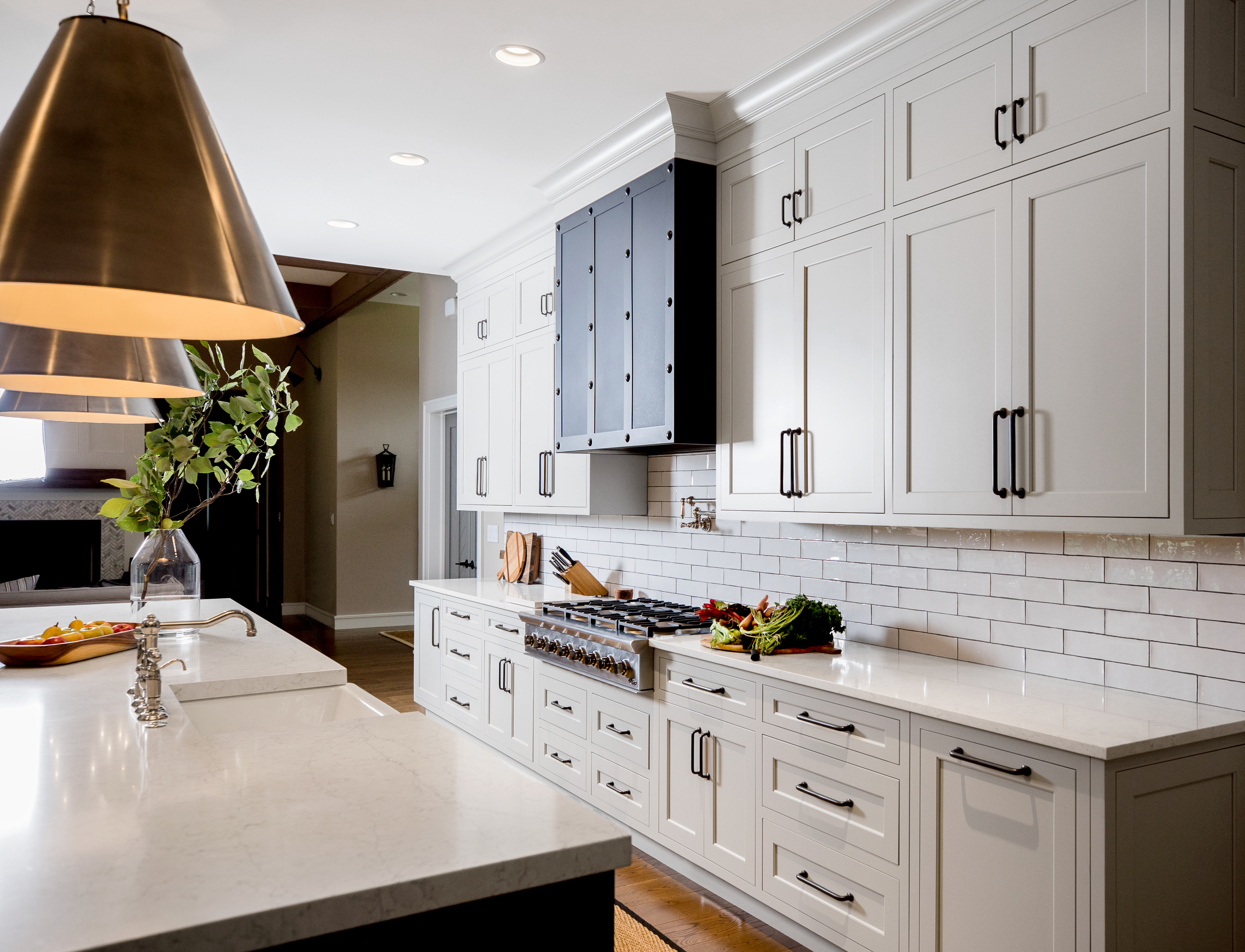 An elegant modern farmhouse kitchen design with sleek framed kitchen cabinets with inset cabinet door construction. The kitchen cabinetry is shown in an off-white painted finish with a classic shaker inset door style.