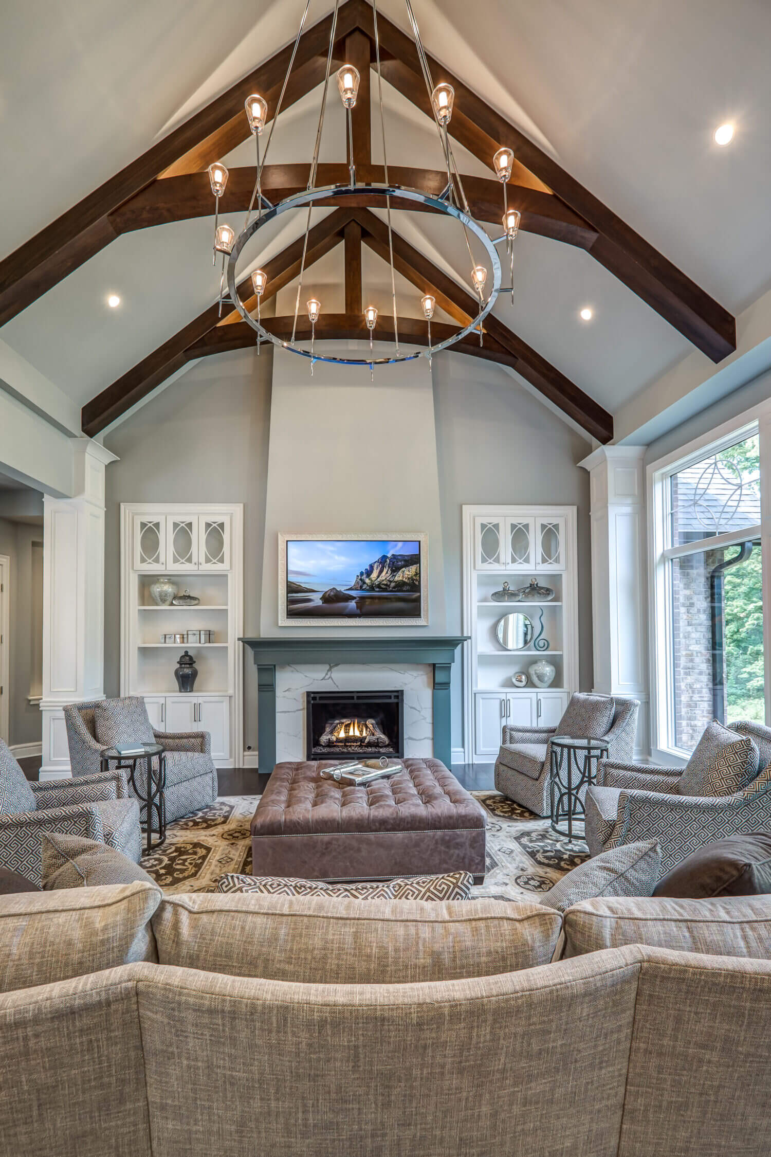 This family room features a green painted fireplace mantel with white painted cabinets flanking the fireplace and built into the walls.