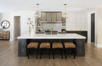 A modern farmhouse dream kitchen with dark gray stained oak for the base cabinets and white painted shaker wall cabinets.