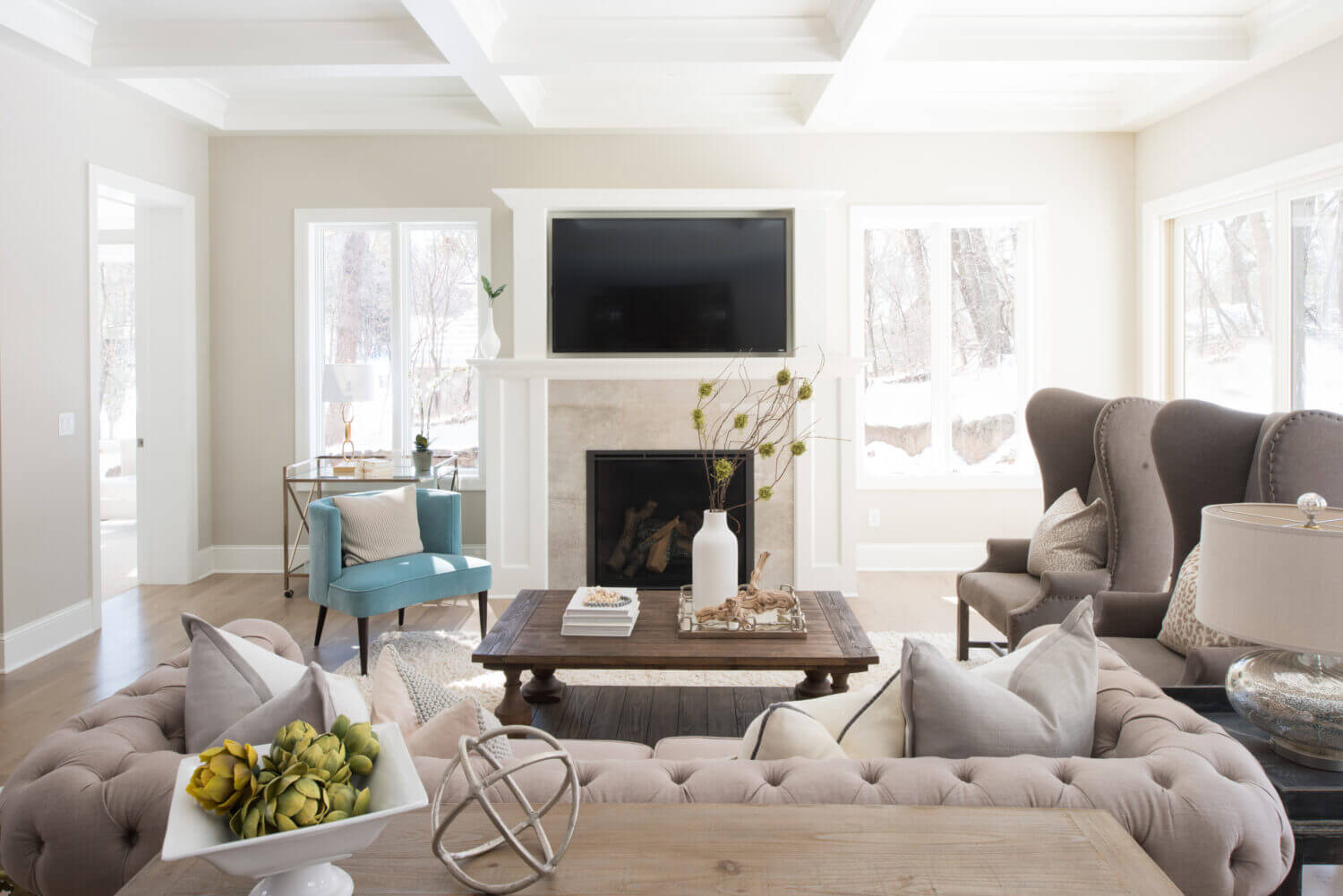 A look over the couch in the living room showing the fireplace mantel that coordinates with the kitchen cabinets and millwork throughout the home.