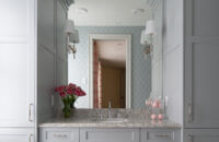 A soft, light gray painted bathroom vanity with two tall linen cabinet towers on both sides of the vanity creating a very symmetrical design.