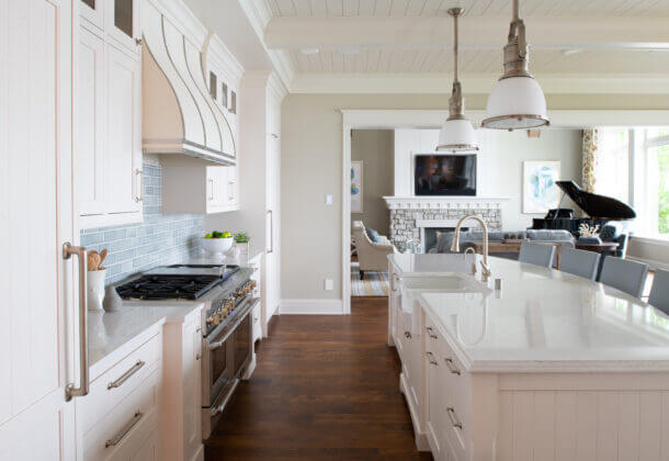 An East coast shingle styled kitchen with a symmetrical design using white painted inset cabinets and shiplap details.