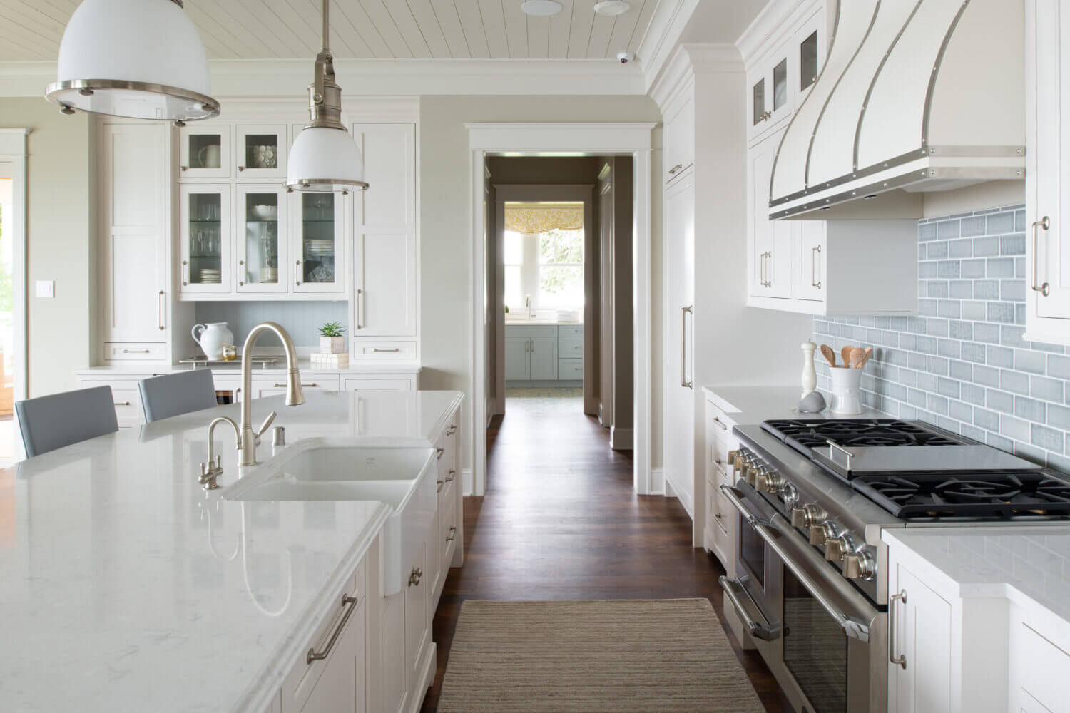 An all-white kitchen design with custom inset cabinets and shiplap and light blue accents.