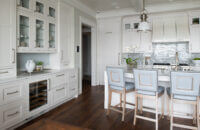 A coastal style kitchen with white painted cabinets with inset construction and shaker style doors.