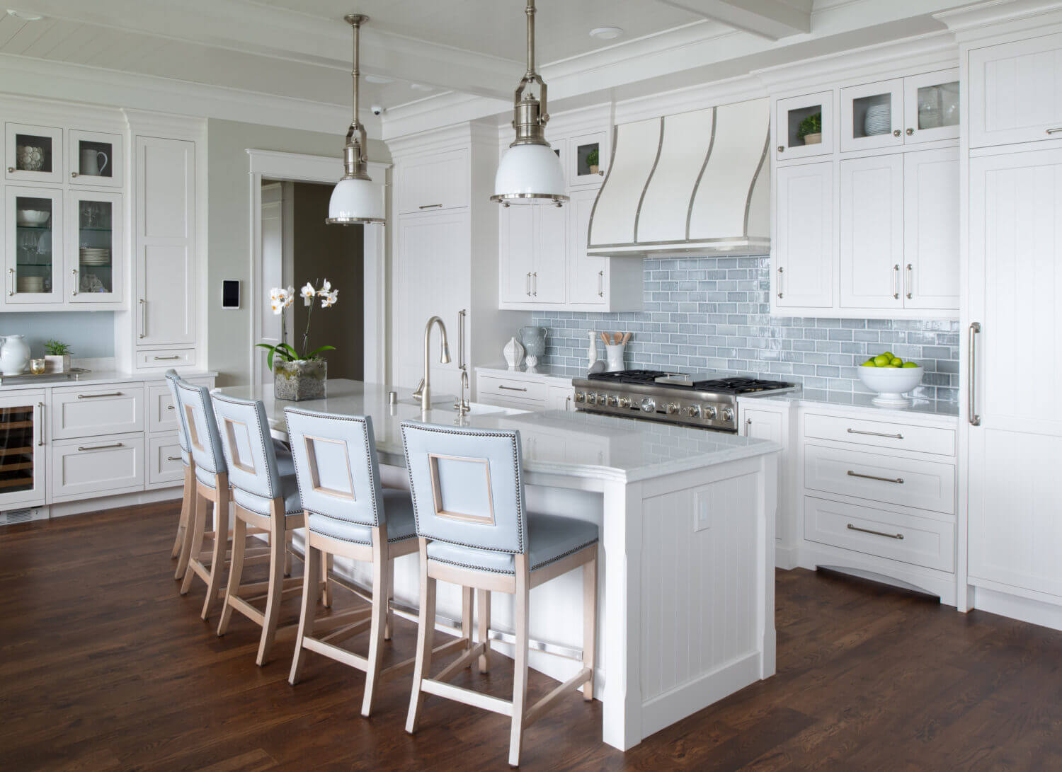 An East coast shingle styled kitchen with a symmetrical design using white painted inset cabinets and shiplap details.