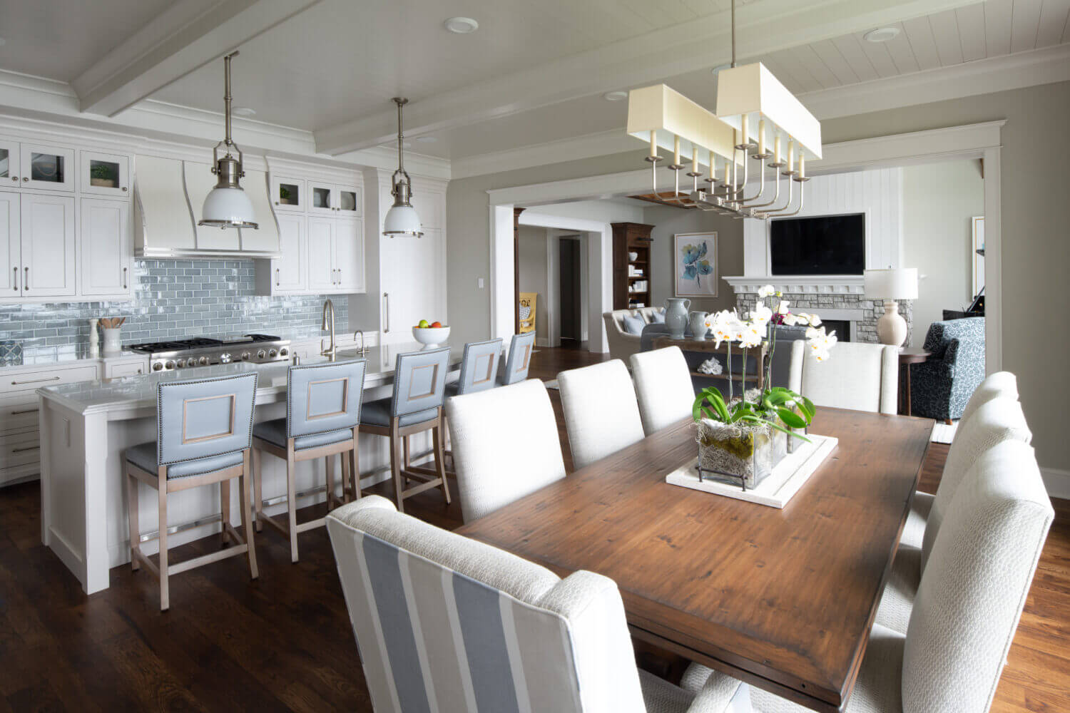 A look from the dining room into the kitchen with an East Coast Shingle style using white painted inset cabinets..