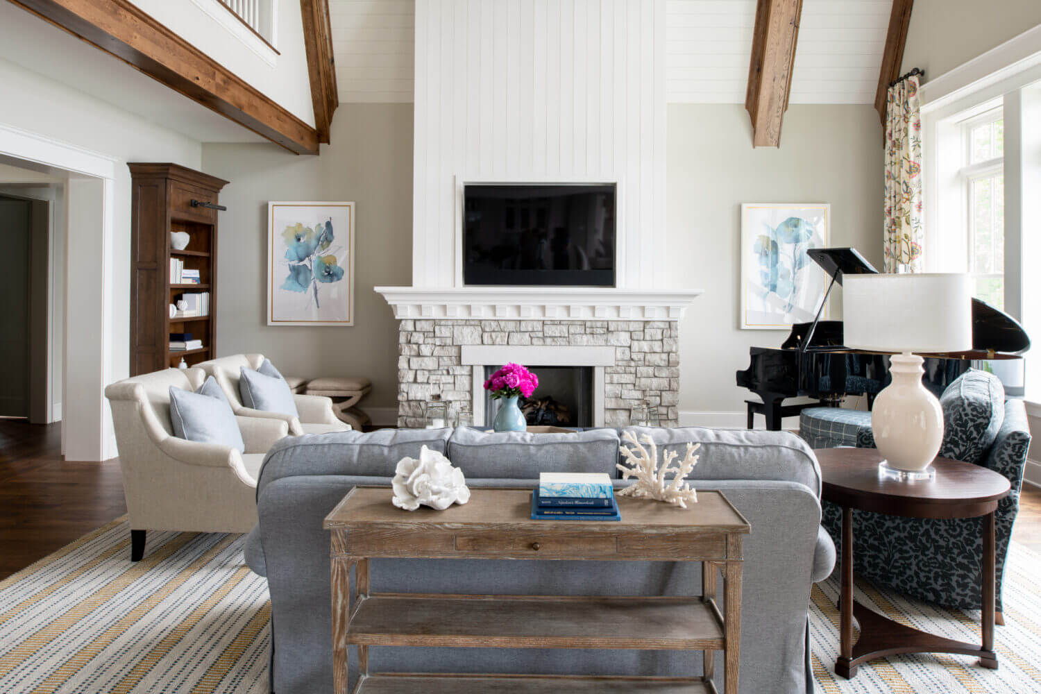 A coastal style living room with built-in bookcases and cabinetry from Dura Supreme with a beautiful fireplace design.