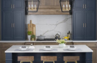 A colorful modern farmhouse kitchen with navy blue and gray stained hickory cabinets and a blue shiplap kitchen island.