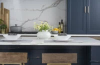 A close up of kitchen island seating at a navy blue kitchen island in a beautiful modern farmhouse kitchen.