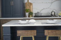 A dark blue kitchen island with shiplap details in a modern farmhouse style kitchen.