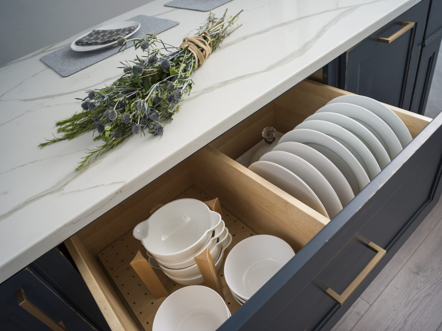 A deep kitchen drawer with two kinds of plate and dish organizers.