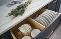 A deep kitchen drawer with two kinds of plate and dish organizers.